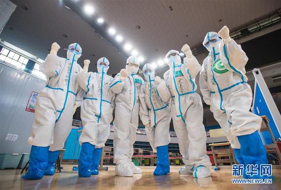 3月10日，武汉武昌方舱医院正式休舱，医护人员在送走新冠肺炎治愈患者后合影留念。新华社记者 肖艺九 摄
